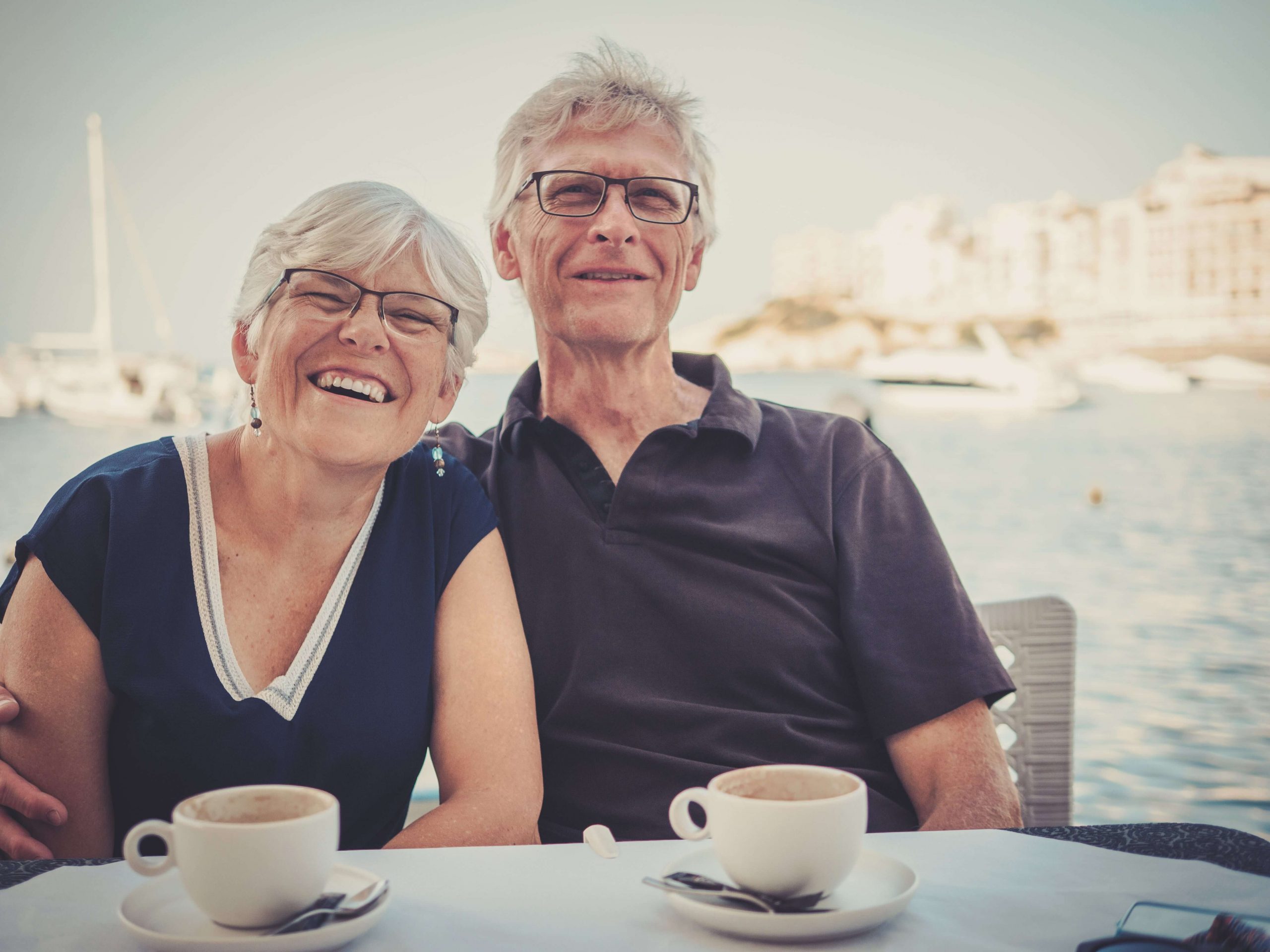 Couple sitting waterfront with coffee